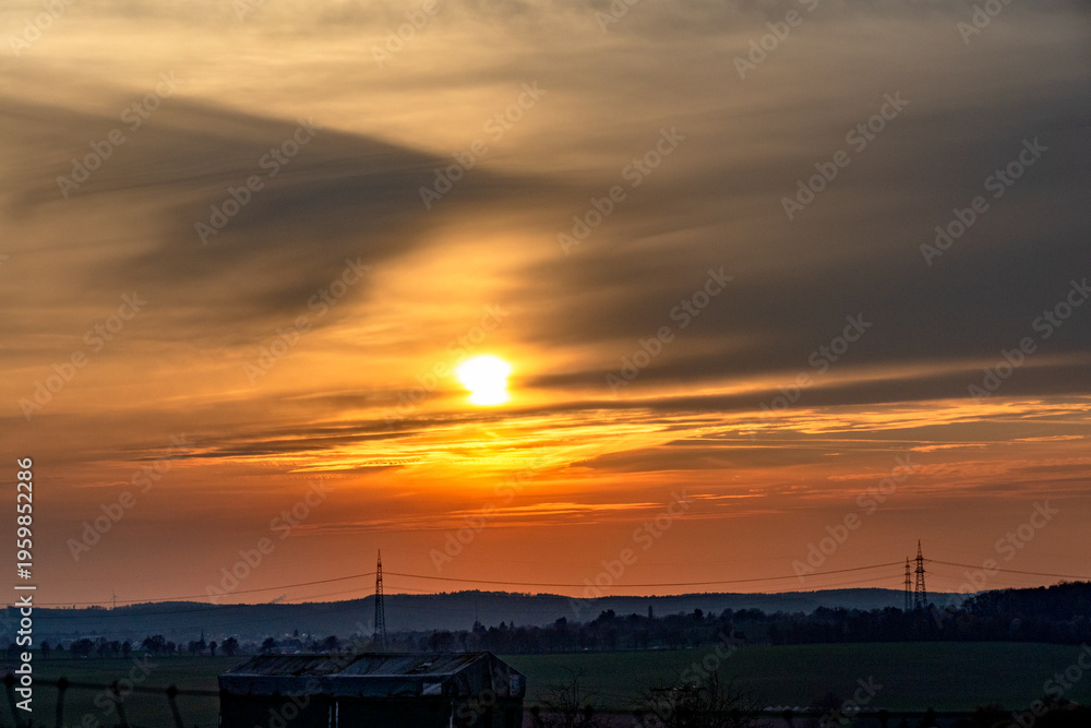 Fototapeta premium Sonnenuntergang und Hochspannungsmasten