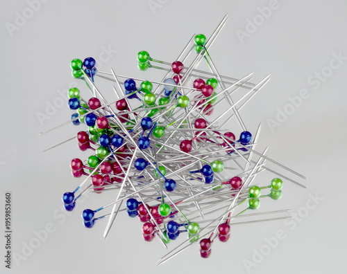 pins with colorful round heads on a mirror with gray background