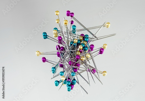 pins with colorful round heads on a mirror with gray background