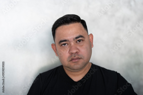 Angry young asian man with a facial expression, showing negative emotions. Irritated person aggressive teenager looking at camera, front view