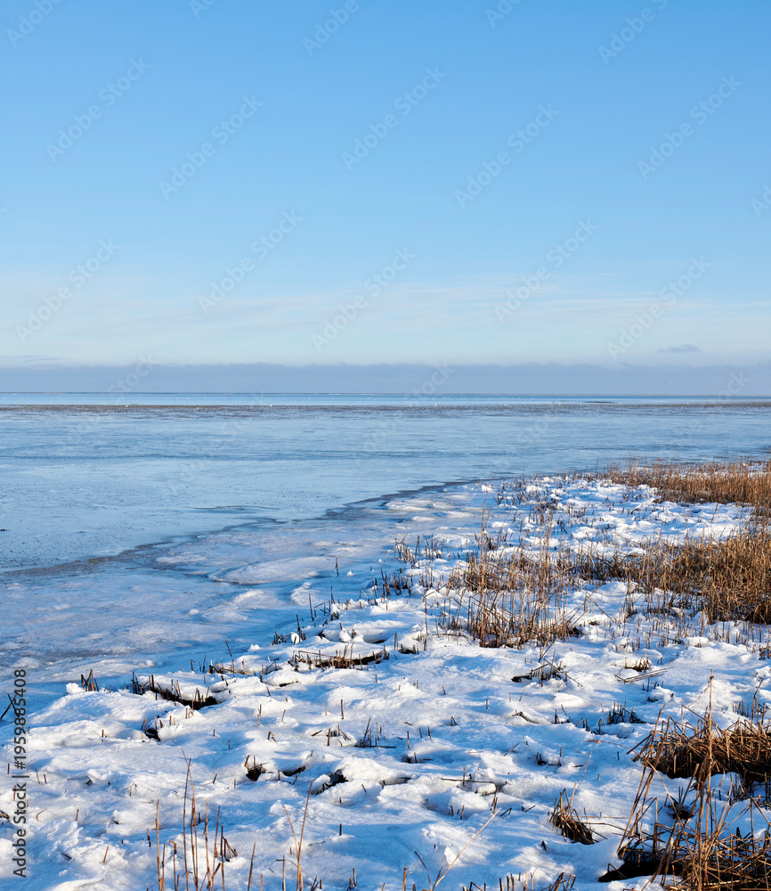 Obraz premium Landscape, frozen and lake with ice in nature for climate change, winter season and morning frost. Space, blue sky and river with snow formation, freezing field and icy conditions from global warning