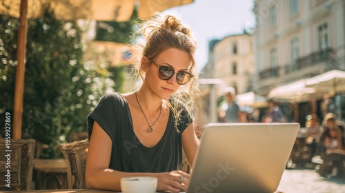 Wallpaper Mural Spring Summer outdoor leisure relaxation activity. A vivid outdoor portrait of a woman seated at a wooden table in a Europeanstyle cafe. She intently focused on her laptop. Torontodigital.ca