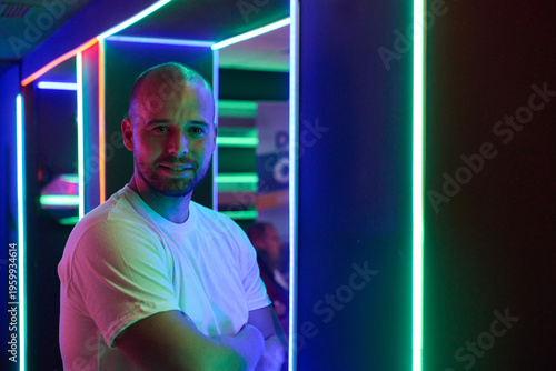 Tableau sur toile Confident Man Portrait in Neon Lights at Nightclub With Arms Crossed and Casual
