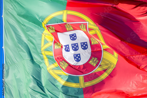 Portugal flag waving in the wind against blue sky