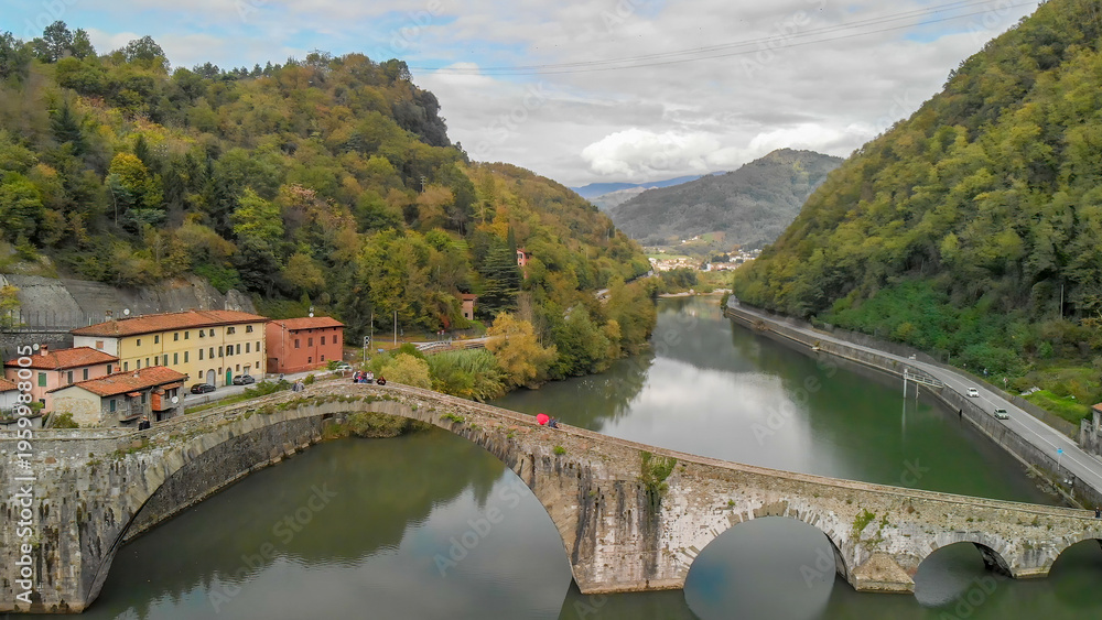 Fototapeta premium Breathtaking aerial view of Tuscany’s Devil’s Bridge amidst lush greenery and rivers