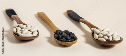 Alubia blanca y frijol negro de Brasil sobre tres cucharas de madera