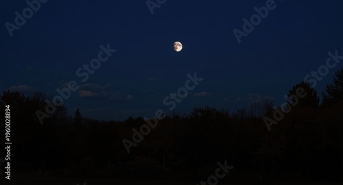 Moon at first quarter casting light on a cold autumn dusk