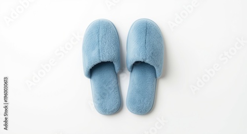 Inviting home comfort with soft blue slippers laid on clean white minimal backdrop