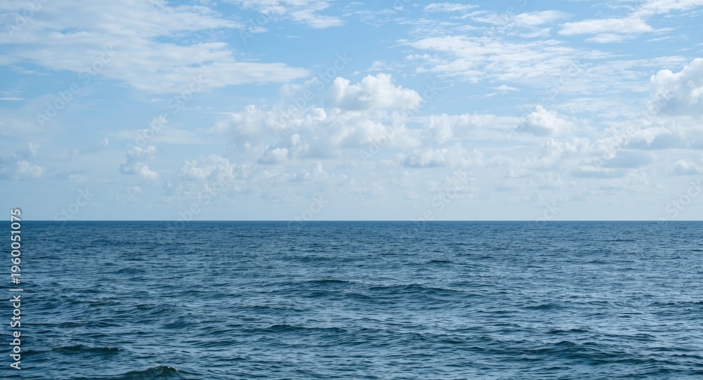 Obraz premium mild ocean scene presenting calm sea surface and cloud-speckled sky