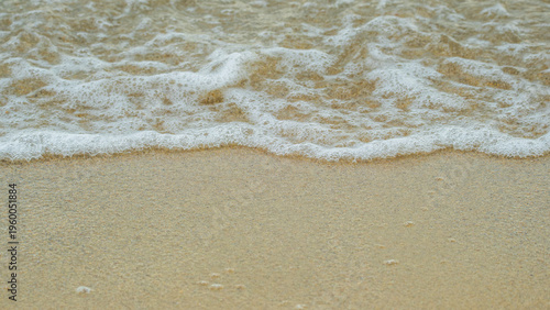 Billede på lærred Soft ocean foam gently washing over a golden sandy beach