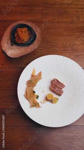 dishes of haute cuisine presentation serving details in dishes. chef hands put greens flowers sauce on plate. close up white plate in restaurant. food in Michelin restaurant. modern cooking technology