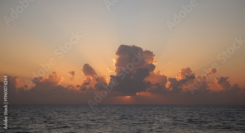 Radiant dawn above tranquil sea showcasing vivid cloud formations