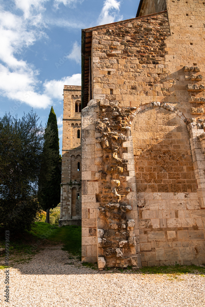 Fototapeta premium Abbazia di Sant'Antimo wall with bell tower in Montalcino, Tuscany, Italy.