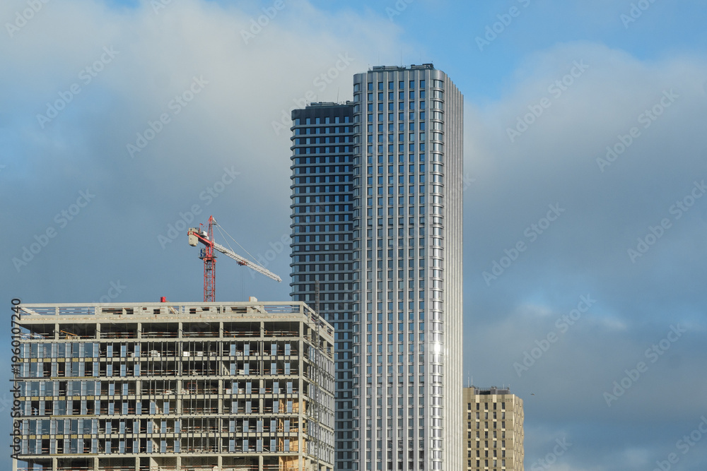 Fototapeta premium Construction of Modern Buildings in a City Skyline With Clouds in the Background During Daytime