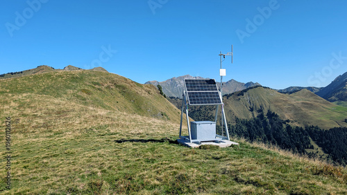 Remote autonomous weather station powered by solar panel installed in high mountain landscape. Concept of renewable energy, meteorology, sustainability, and technology in nature.
