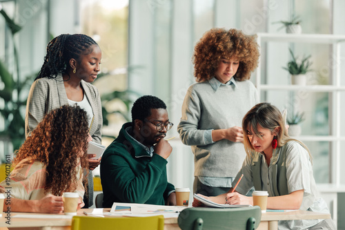 Photos Diverse business team collaborating during an office meeting
