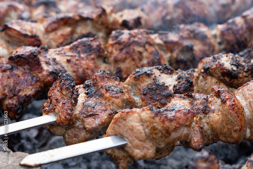 Cooking delicious meat on the grill. Red meat on an open fire. Food in nature