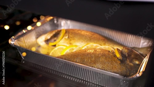 Dorado fish is baked in the oven. Pickled with spices and lemon. Bubbles of boiling oil. Close-up.