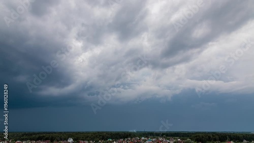 Dramatic rain storm moving over the landscape with lightning strike hitting the ground.