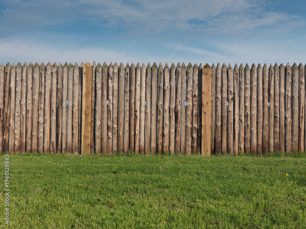 Fototapeta premium Historic old wooden palisade fence stakes, fenced fort wall.