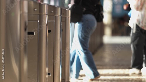 Commuters passing through subway station turnstiles