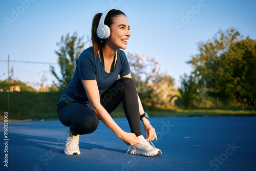 Slika na platnu Woman lacing up running shoe preparing for jogging workout