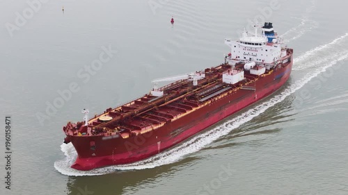 massive red oil chemical tanker cruising steadily across pale waters deck packed pipelines cargo long smooth aerial fuel gas crisis sea gulf qatar iran war 