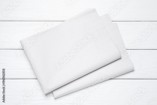 Newspapers on white wooden table, top view. Mockup for design