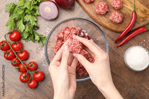Картината върху платно Woman making meat balls with minced beef at wooden table, top view