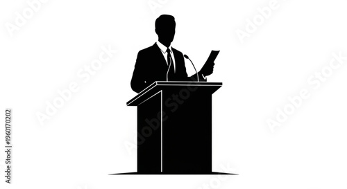A businessman stands at a podium, speaking into microphones and holding papers, conveying a speech or presentation to an audience.