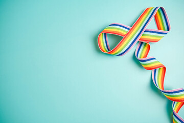 Autism acceptance month, Autism awareness day concept. Rainbow ribbon in shape of infinity on blue background