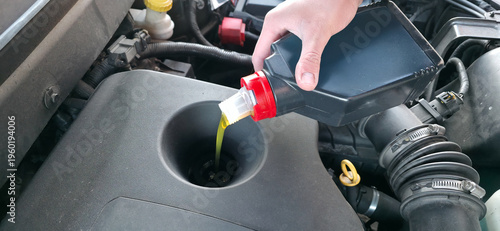 Canvastavla A man is adding motor oil to a car engine