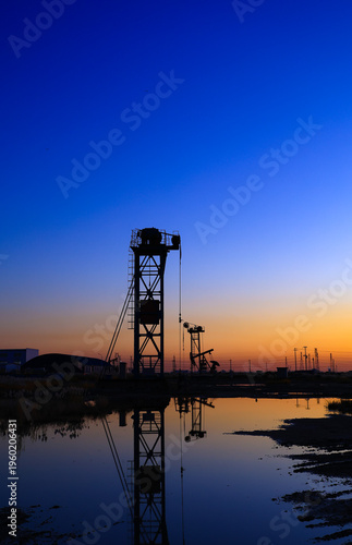 The oil pumping unit is operating in the evening outdoors