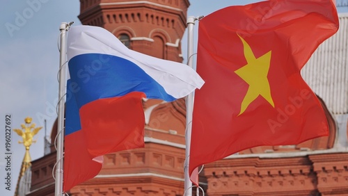 Russian and Vietnamese flags waving together in front of a historic building