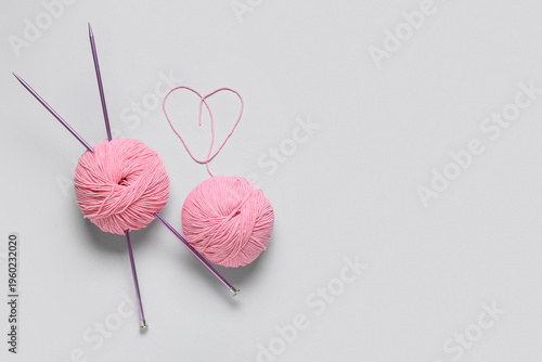 Pink yarn with needles on g...