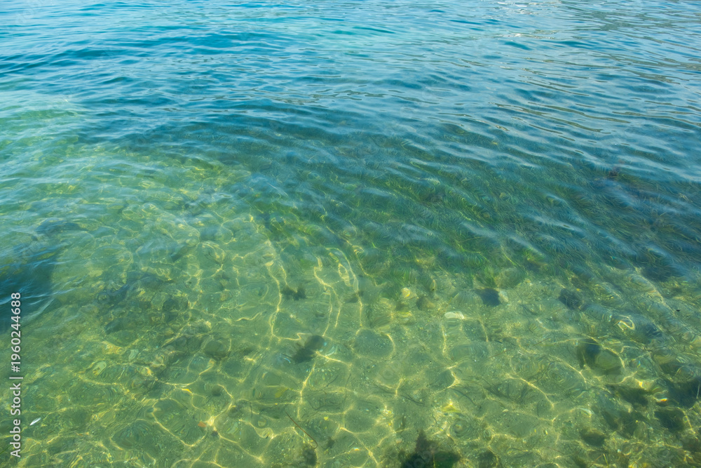 Obraz premium Clear turquoise water, sunlight reflecting, symbolizing natural beauty and serene aquatic scene, bottom through transparent water, blue background, natural resources planet