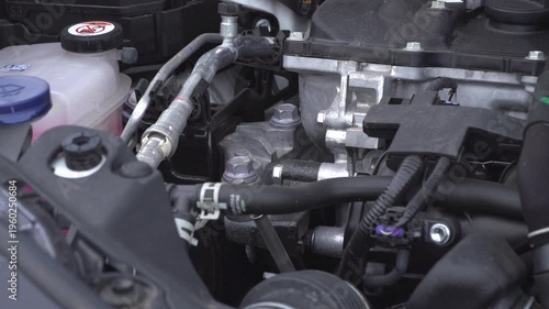 Mechanic checking car engine oil level with yellow dipstick