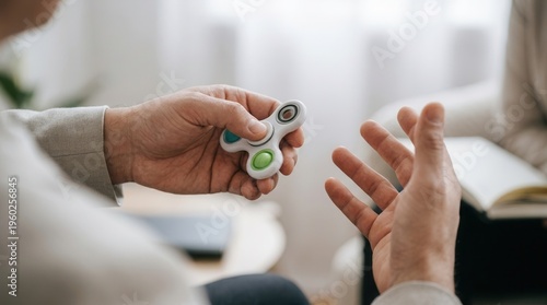 Hands spinning fidget toy during counseling session for anxiety relief and adhd focus mechanism concept.

