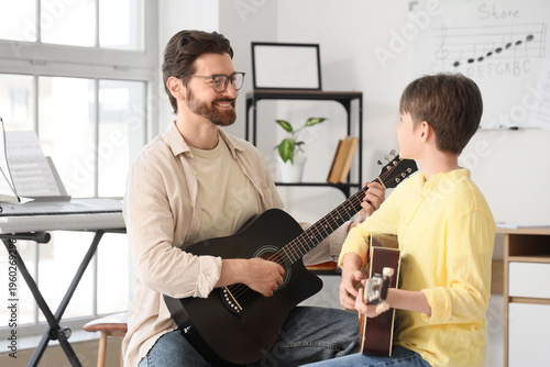 Music teacher giving guitar...