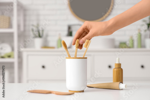 Woman taking toothbrush fro...
