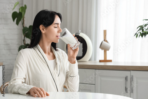 Beautiful woman drinking mi...