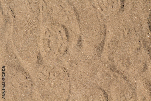 Footprints and shoe prints on sand texture background