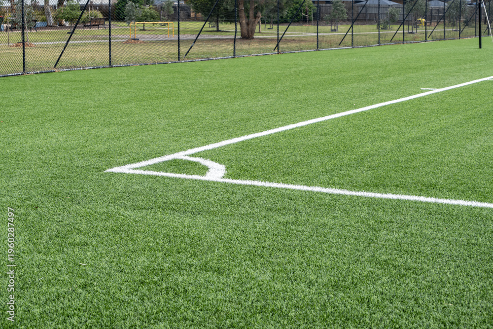 Fototapeta premium Artificial turf sports field in a public park in Australia, featuring a well-maintained synthetic grass surface. Community sports facilities, low-maintenance landscaping, and outdoor recreation