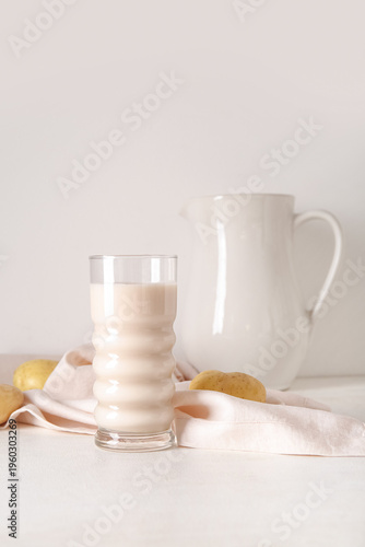 Glass of tasty potato milk ...