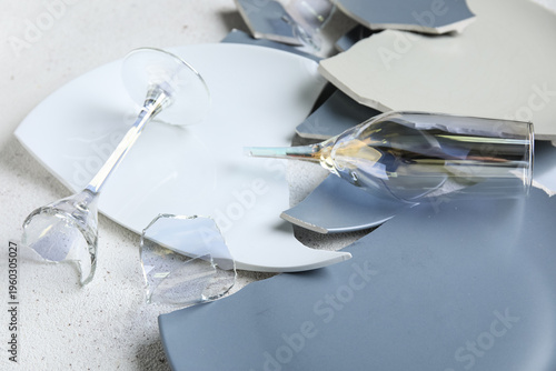 фотографія Broken plates and glasses on grunge table, closeup