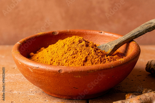 Ground Turmeric Powder in a Rustic Terracotta Bowl