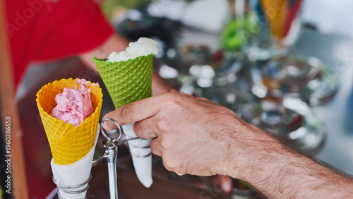 Man buying refreshing strawberry and lemon ice cream cones from a street vendor
