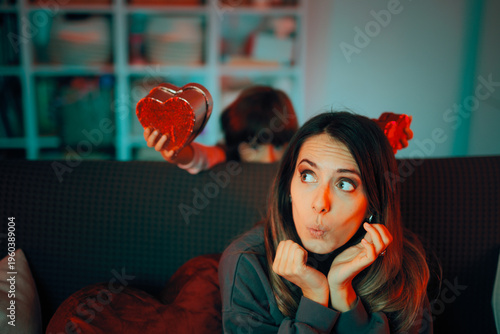 Mother Receives Surprise Gift from her Child. Young mother is being surprised by her child with a heart shaped box present
