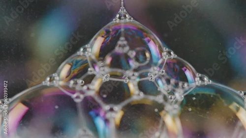 Liquid soap bubbles forming macro calm with iridescent surfaces and delicate reflections