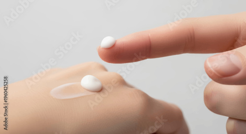 Close-up of Finger Applying Cream to Hand for Skincare and Hydration
